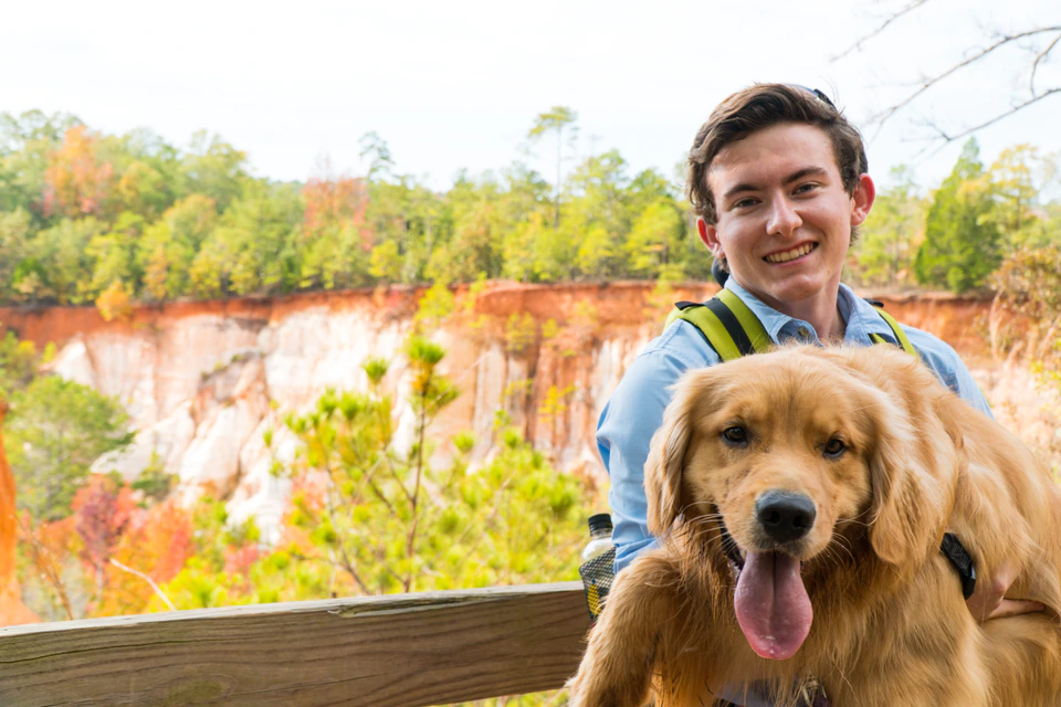 Matt with Lucy the golden retriever, the original Red Paw